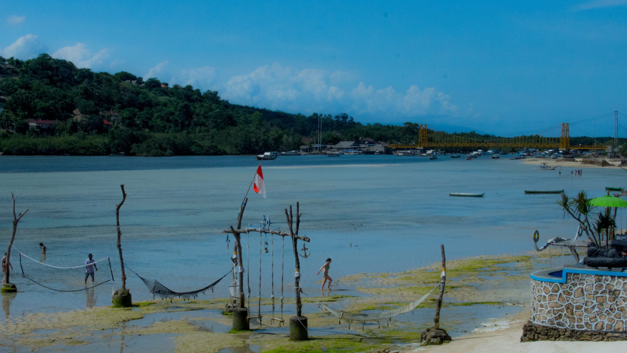De zeestraat tussen Nusa Lembongan en Nusa Ceningan, met op de achtergrond de beruchte gele hangbrug.